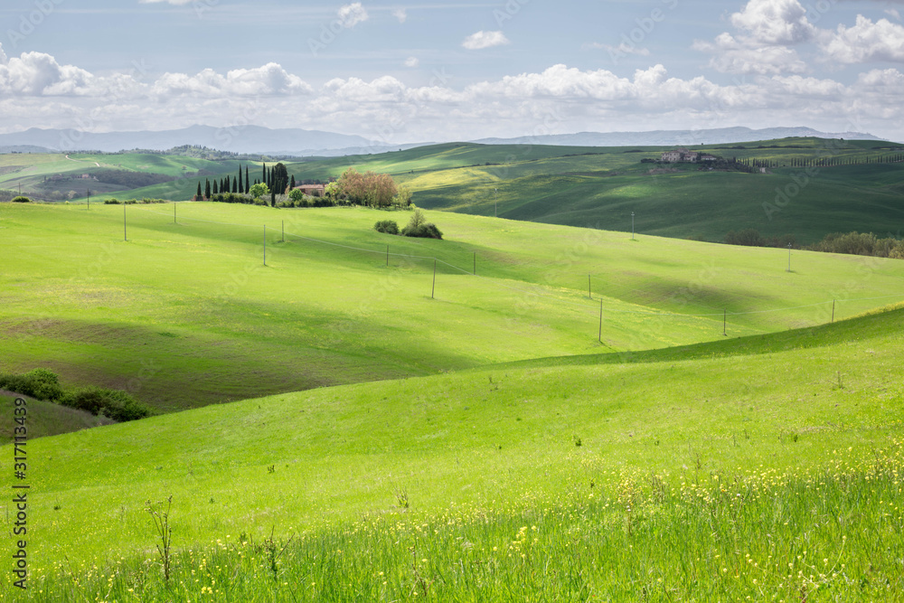 Colline Toscane con casale sullo sfondo immerso nelle verdi colline
