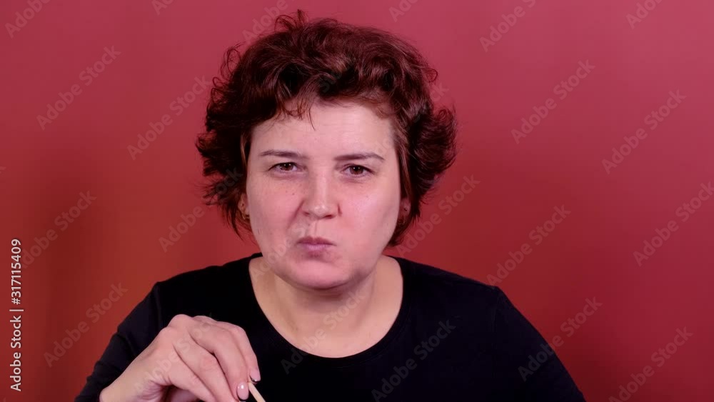 Adult woman eating sushi with a chopsticks. Adult woman eating sushi with a chopsticks.