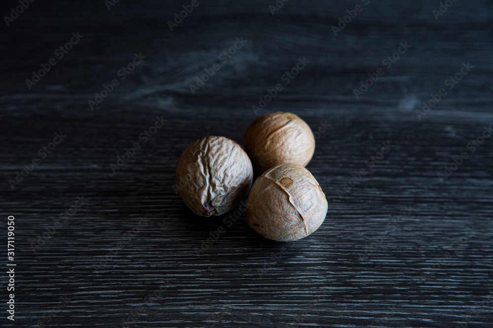 Low key image of 3 different sized avocado seeds in a group. Hard light ...