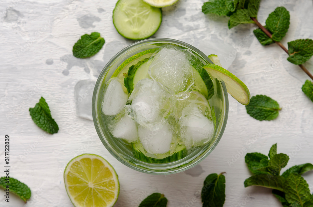 Infused water on a glass. Detox water mix of cucumber, lemon, lime and mint. - obrazy, fototapety, plakaty 
