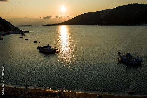 Boats parking in the Mediterranean sea bay, golden light scenery during morning sunrise photo