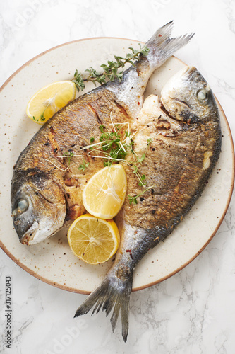 Cooked dorado fish with lemons and herbs