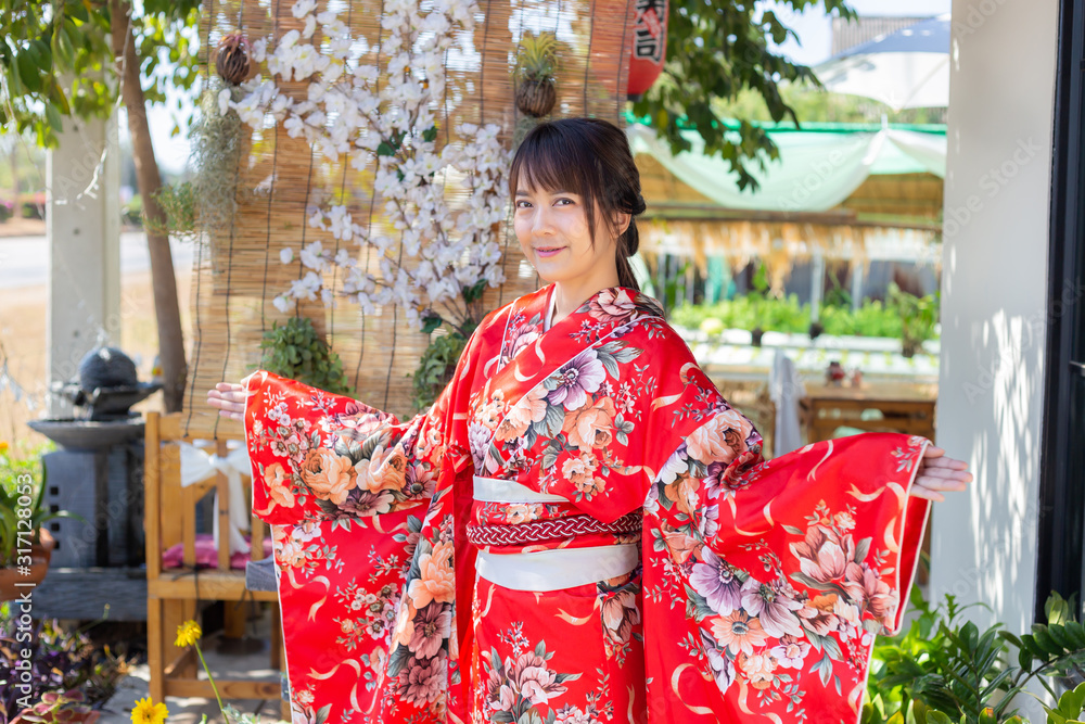 The girl is wearing a red traditional kimono, which is the national dress of Japan