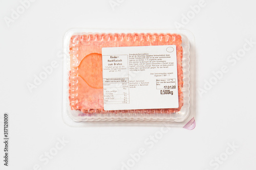 Black plastic pack with fresh hash isolated on white background. Raw meat packed with label top view, Symbol for environmental pollution done by the food industry