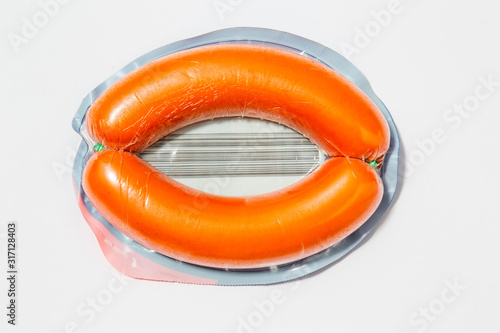 Use less plastic! pork sausage in plastic packaging isolated on white ground. Symbol for environmental pollution done by the food industry