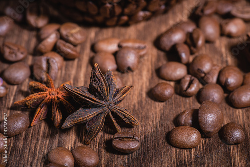 Background for coffee beans in dark colors for the background. Coffee Coffee Beans Cinnamon Stick Anise Star Wooden Table Close-up. © Андрей Прилуцкий
