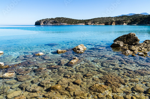 Beautiful idyllic turquoise waters coast with pebbles and rocks.