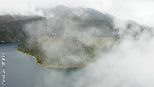 Aerial flies backwards covering the view with Fog. Cuicocha Islands. Otavalo, Ecuador.