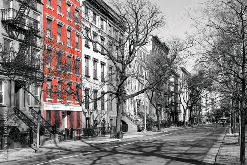 Photography Red brick building highlighted on a block of old black and white buildings in th