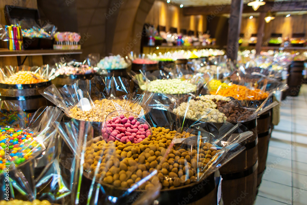 Obraz premium Confectionery shop in retro style. Colorful candies and sweets in wooden barrels.
