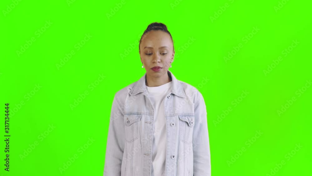 Shoot of african american woman looking at camera on green background Jean jacket Shoot of african american woman looking at camera on green background Jean jacket