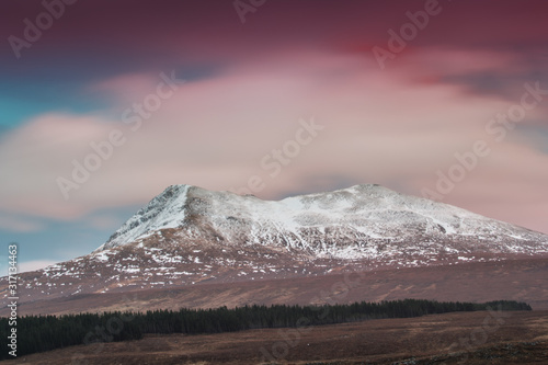red sky colour in sunset of ice and snow covered hills in Scotland winter season