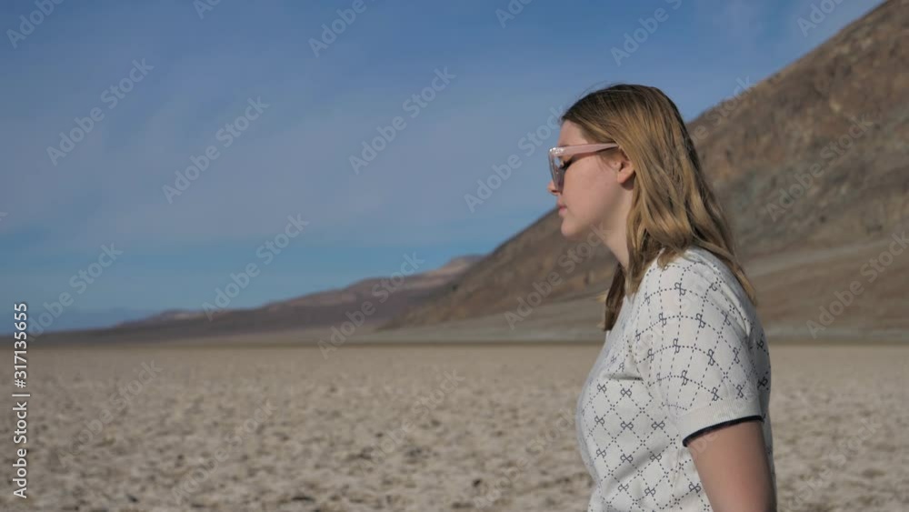 Millennial girl on holiday walking on salt lake Death Valley sunny day outdoors Millennial girl on holiday walking on salt lake Death Valley sunny day outdoors