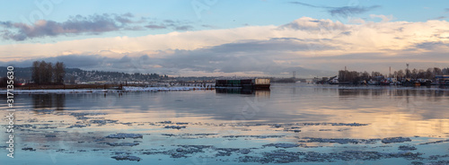 Beautiful Panoramic View of Fraser River in the City during a cold and icy winter sunset. Taken in New Westminster, Vancouver, British Columbia, Canada.