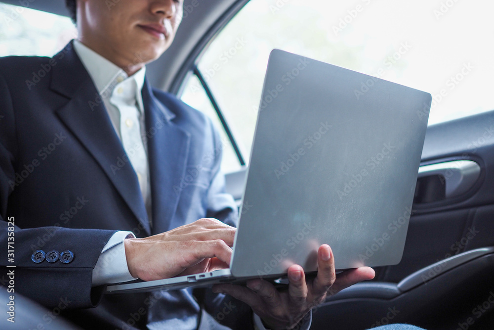Businessman using laptop working on the car. The trip to the provinces. Businessman using laptop working on the car. The trip to the provinces.