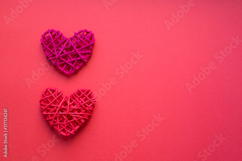 Two red wooden hearts on a red background. Love and Valentine day concept