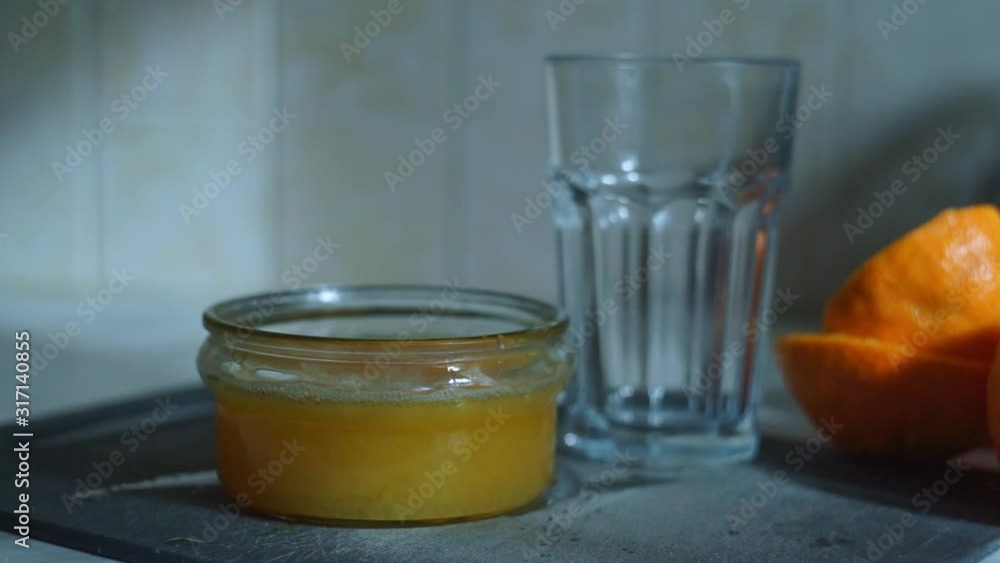 Man puts fresh squeezed orange juice in a glass Man puts fresh squeezed orange juice in a glass