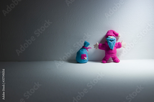funny toy Santa Claus with a bag of colored clay close-up of artistic light © Ruslan