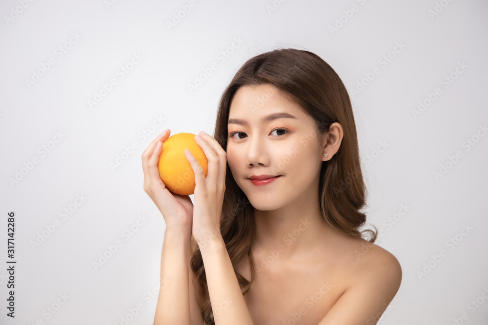 Beautiful Young Asian Woman short hair with Clean Fresh Skin. Face care, Facial treatment, Cosmetology, beauty and healthy skin and cosmetic ideas concept.pretty woman holding half of orange . Beautiful Young Asian Woman short hair with Clean Fresh Skin. Face care, Facial treatment, Cosmetology, beauty and healthy skin and cosmetic ideas concept.pretty woman holding half of orange .