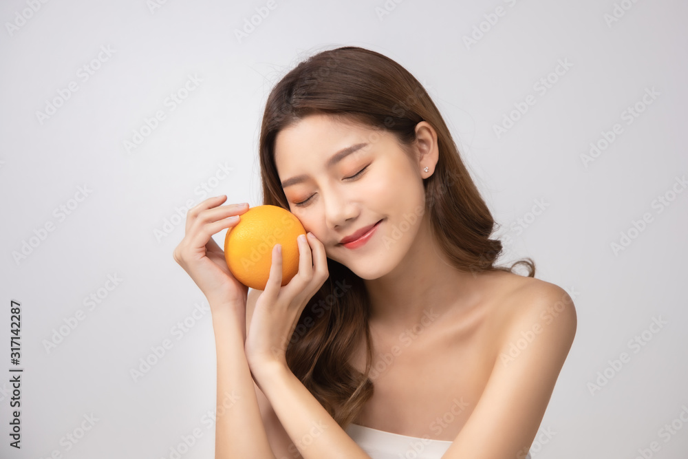 Beautiful Young Asian Woman short hair with Clean Fresh Skin. Face care, Facial treatment, Cosmetology, beauty and healthy skin and cosmetic ideas concept.pretty woman holding half of orange . Beautiful Young Asian Woman short hair with Clean Fresh Skin. Face care, Facial treatment, Cosmetology, beauty and healthy skin and cosmetic ideas concept.pretty woman holding half of orange .