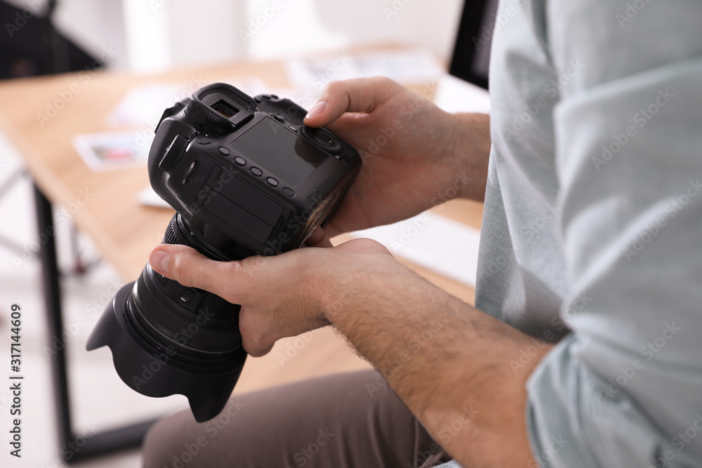 Professional photographer with camera in office, closeup