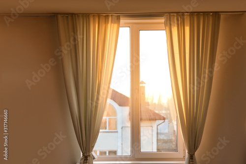Window with beautiful beige curtains. Room decoration