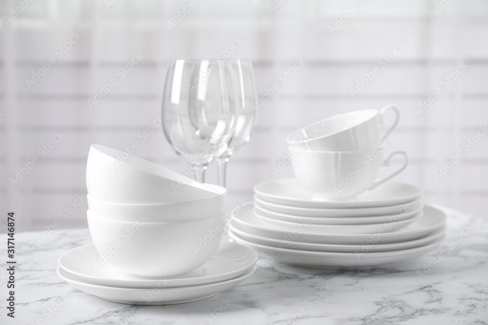 Set of clean tableware on white marble table
