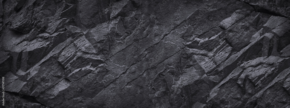 Black stone background. Dark gray grunge banner. Black and white background. Mountain texture. Close-up. Volumetric. The rocky backdrop. Abstract black rock background. Detail.