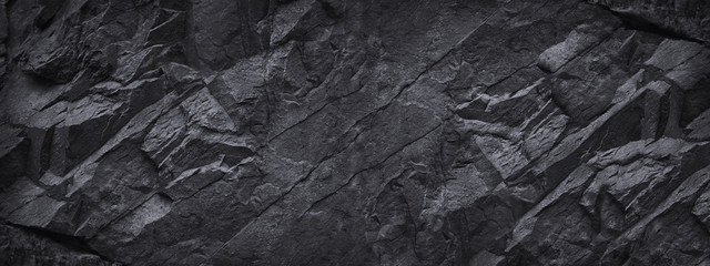 Black white stone background. Dark gray grunge banner. Mountain texture. Close-up. Volumetric.  Rock background with space for design. Detail.  Wide banner. Long. Panoramic.