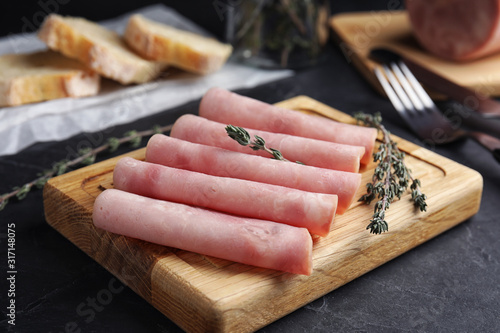 Fotografija Slices of tasty ham on black table, closeup