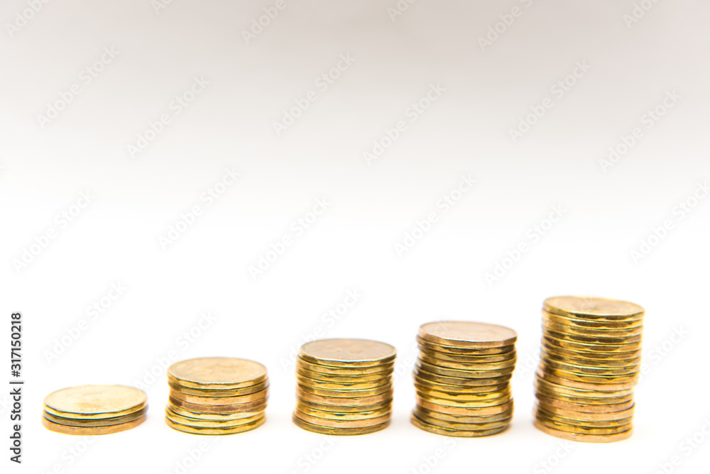 Canadian Dollar coins loonies stacked into five ascending piles on white  background. Stock Photo