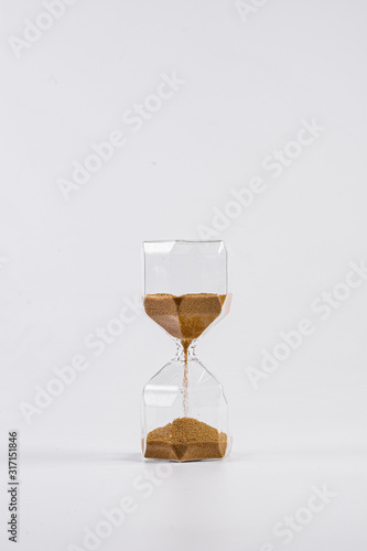 Hourglass with golden sand inside isolated on white background.