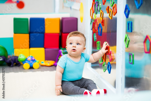 Canvas Print Baby Playing with Colorful Magnets