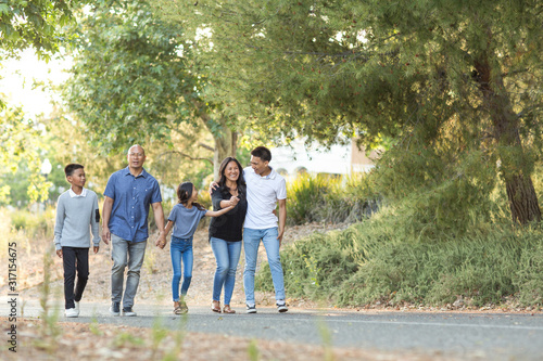 Happy Asian family walking and talking outside.