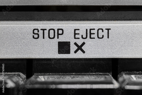 Macro close up photograph of vintage boombox stop and eject button detail.