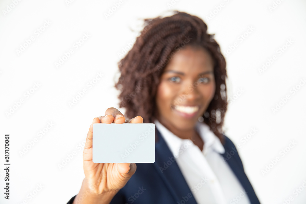 Businesswoman holding card and smiling at camera. Close-up view of cheerful young African American woman holding blank business card, selective focus. Business concept Businesswoman holding card and smiling at camera. Close-up view of cheerful young African American woman holding blank business card, selective focus. Business concept