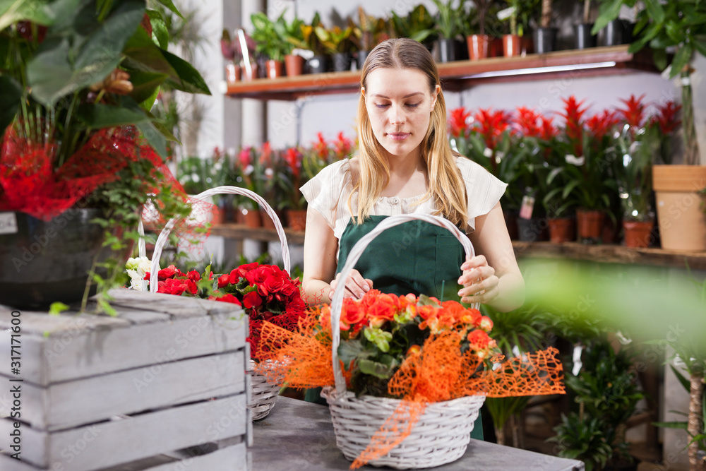 Female florist wearing an apron working in the floral shop