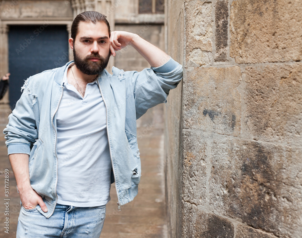 Fototapeta premium Handsome adult man with a beard in a jeans jacket