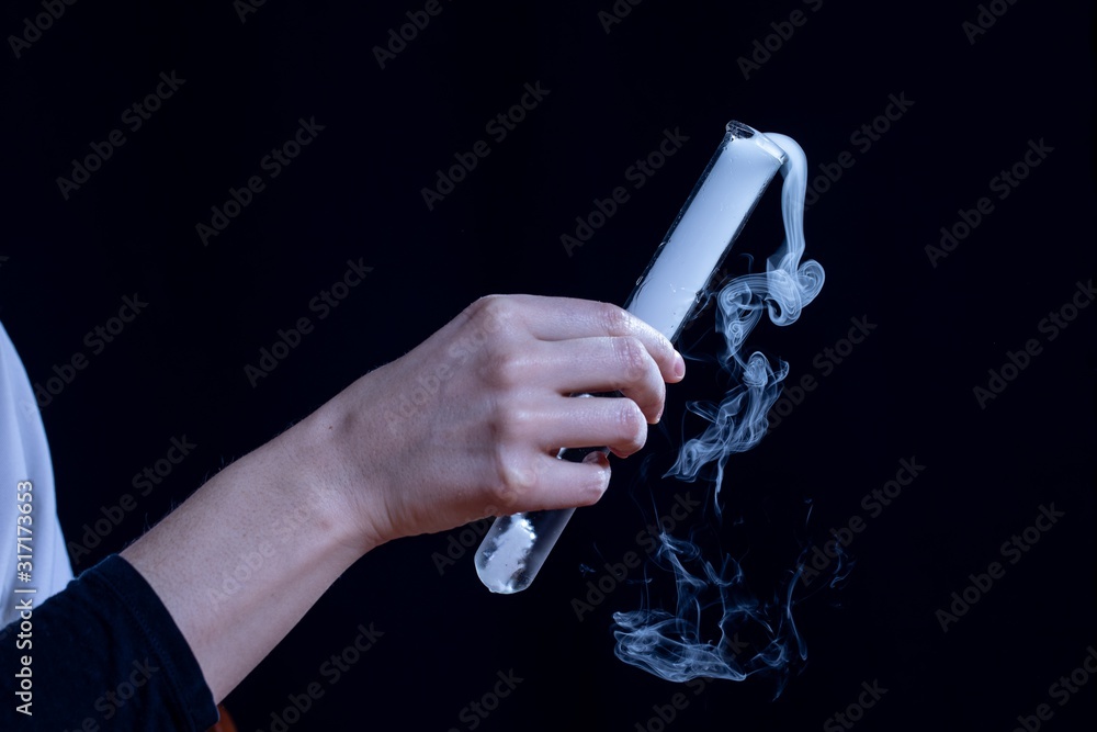 Φωτογραφία Close-up of a hand holding a cylinder with chemical reaction fumes