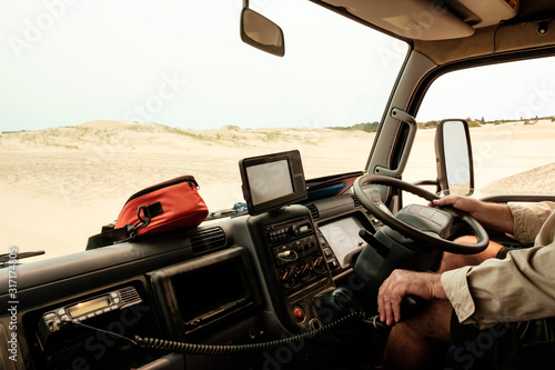 A man driving a tour truck on sand dunes in Australia