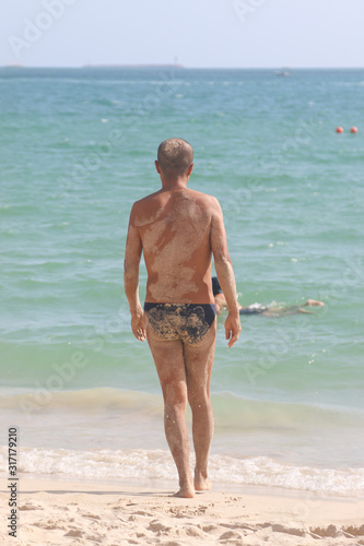 man on the background of the sea in the sand © studybos