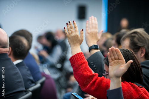  businessman raising hand during seminar. Businessman Raising Hand Up at a Conference to answer a question. photo