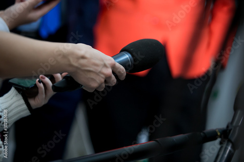Hand with microphone doing an interview for the media, selective focus