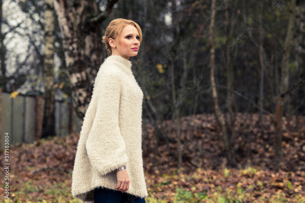Girl posing in a park in a white knit pullover Girl posing in a park in a white knit pullover