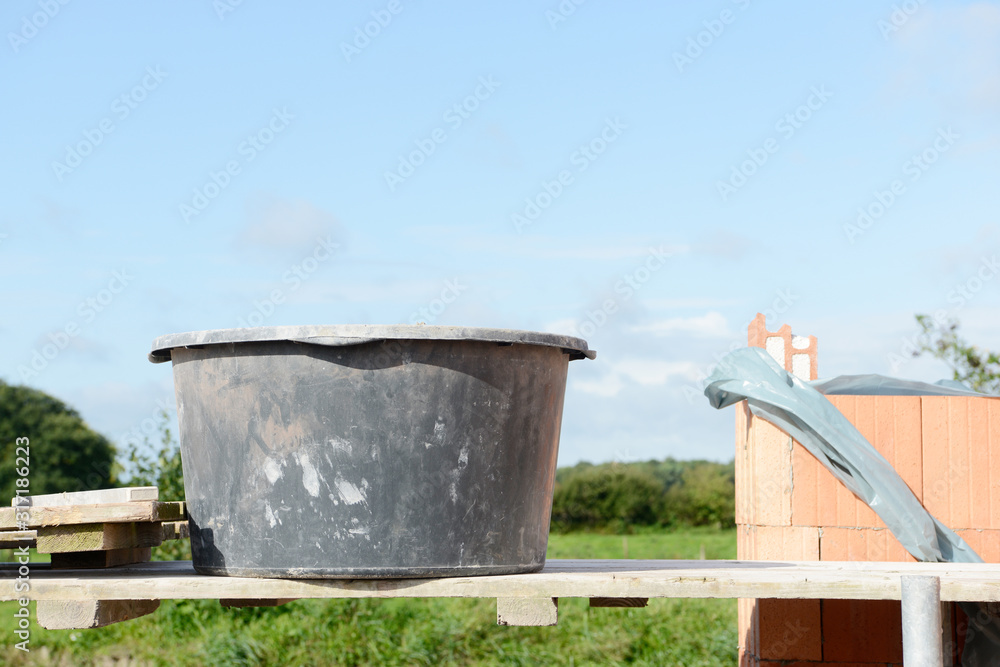 mason bucket and building stones on construction site on wooden scaffolding mason bucket and building stones on construction site on wooden scaffolding