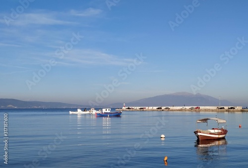 fishing boats in the port on a calm sea with a clear blue sky view