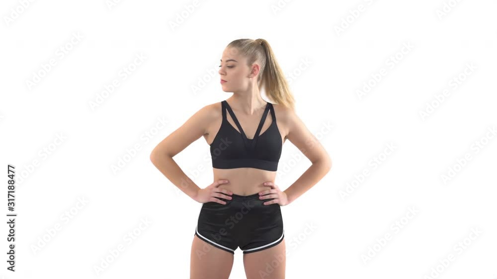 Young slim pretty woman doing fitness exercises for neck health. She turns her head to the right and left. Isolated studio shot on white background Young slim pretty woman doing fitness exercises for neck health. She turns her head to the right and left. Isolated studio shot on white background