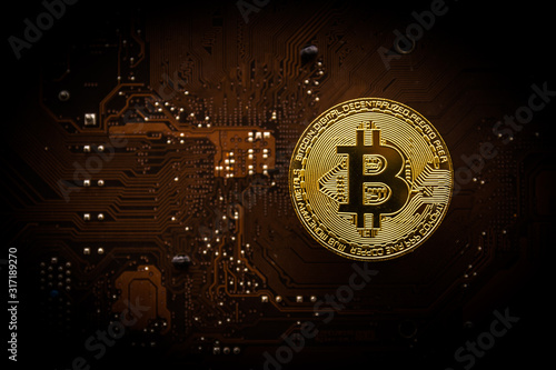 Gold bitcoin on computer mainboard with trading graph, Mining and trade bitcoin concept. 