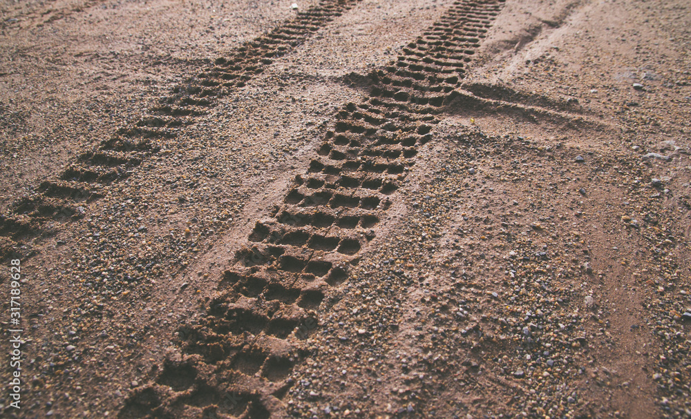Closeup of motorcycle tire track print on sand with selective focus Closeup of motorcycle tire track print on sand with selective focus