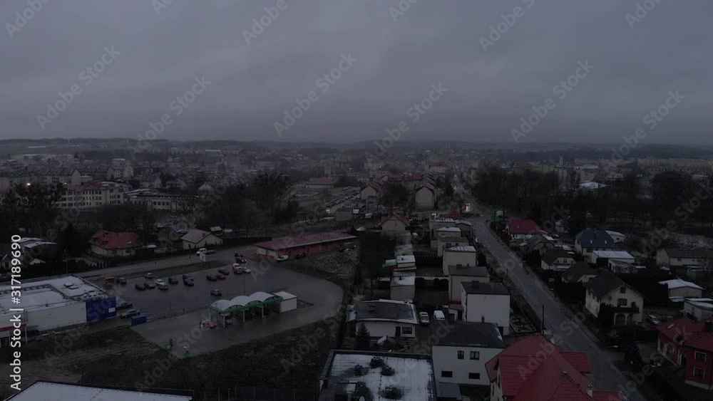 A quiet flight over a small town, cars on the roads, a large car park and a car wash nearby A quiet flight over a small town, cars on the roads, a large car park and a car wash nearby